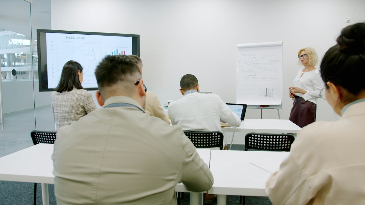 Réunion de travail autour d'un tableau, en salle de conférence